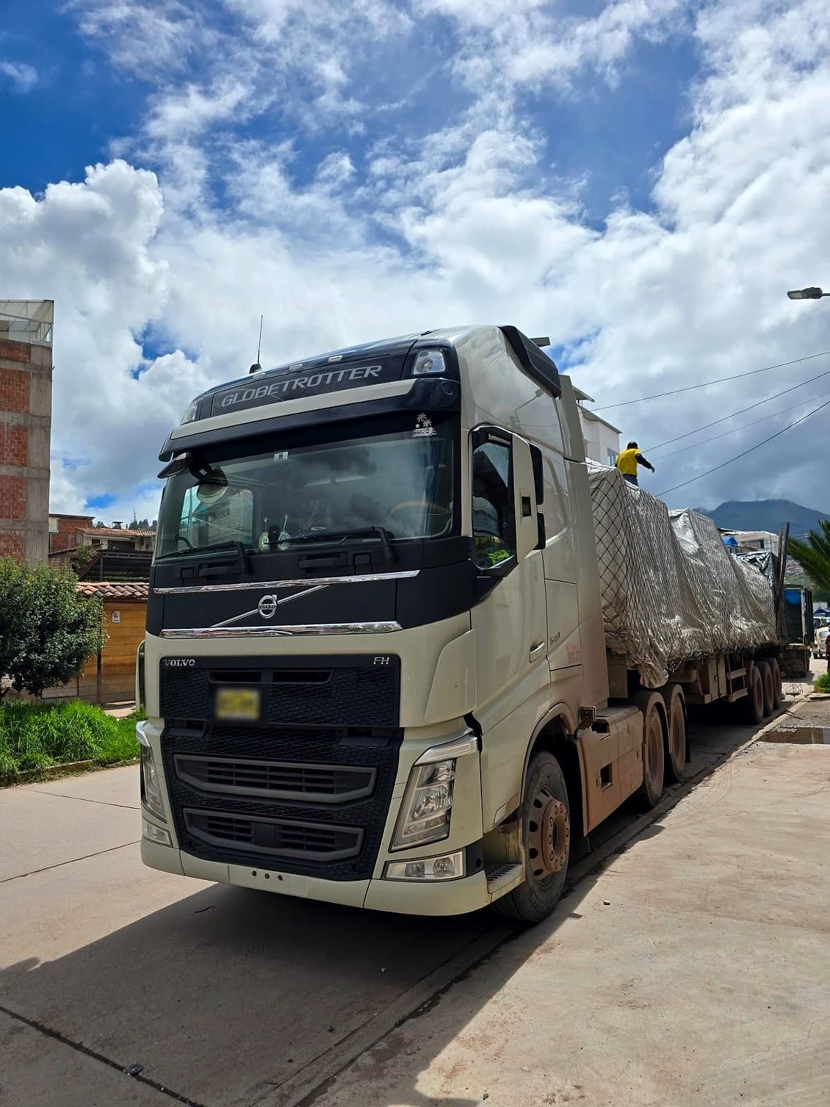 Tracto Volvo de G&I con carga cubierta, estacionado en ruta